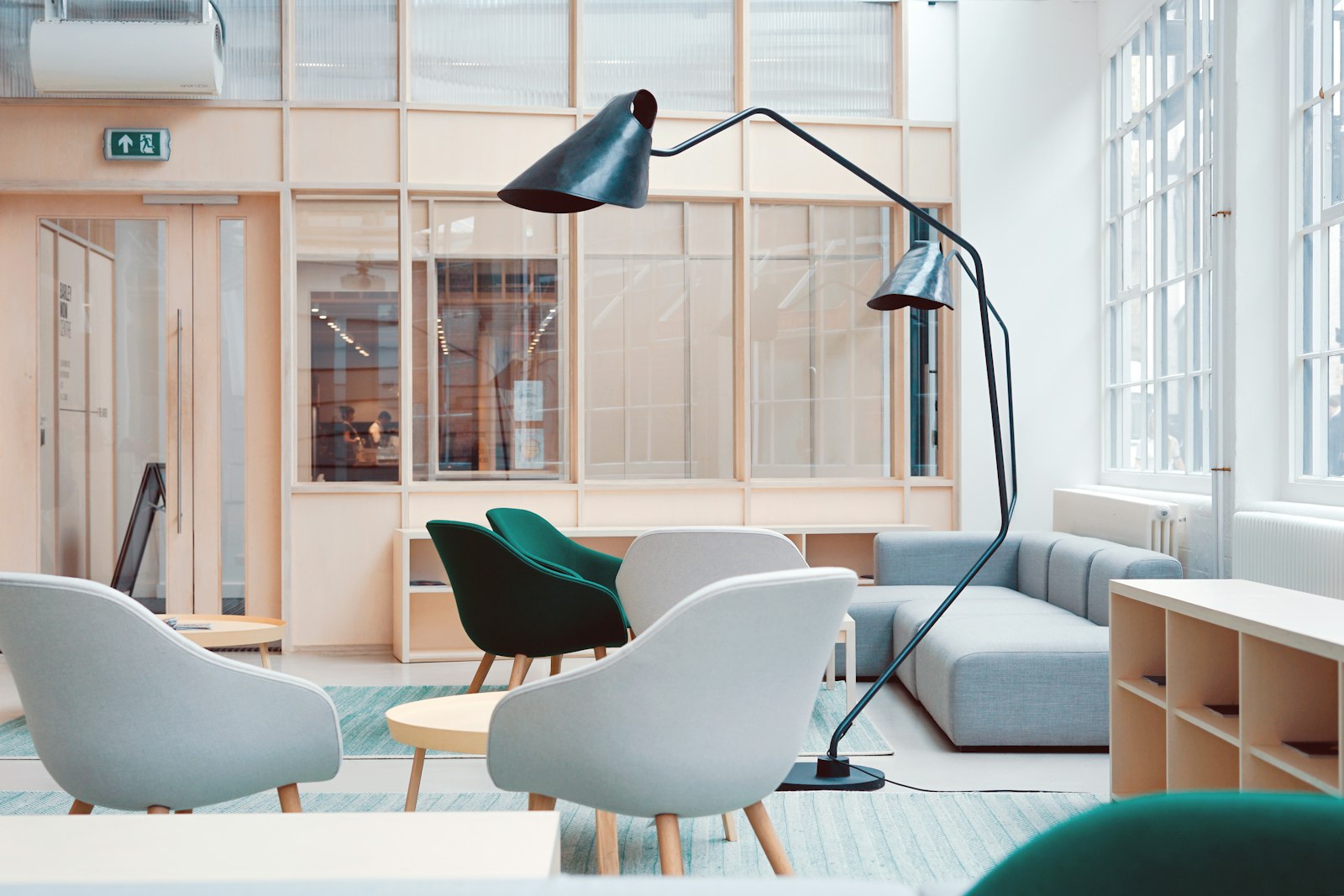 A bright office lounge with lounge chairs and wood-framed glass walls