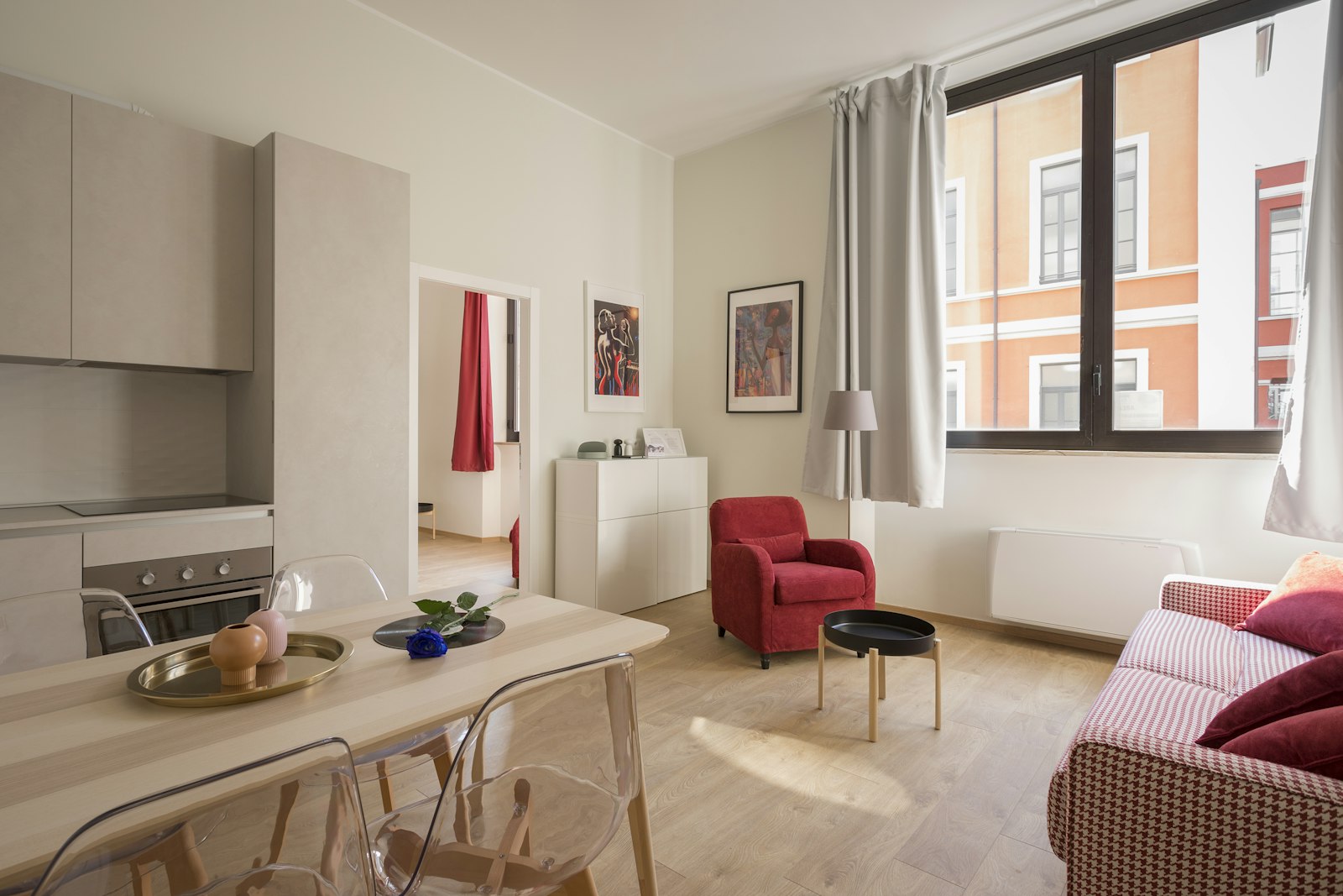 A bright apartment living room with a red armchair